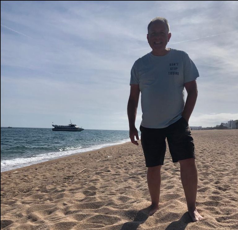 posing on the beach at  Malgrat de Mar with the Senti la Costa Brava boat docking directly on the beach behind me